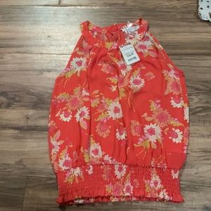 An orange shirt that has never been worn and still has tags from TJ Max